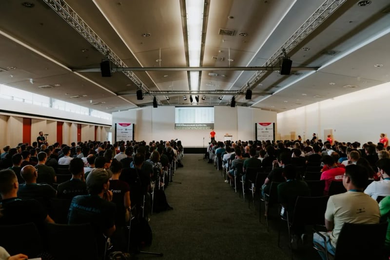 Guests face a presentation stage at a corporate conference.