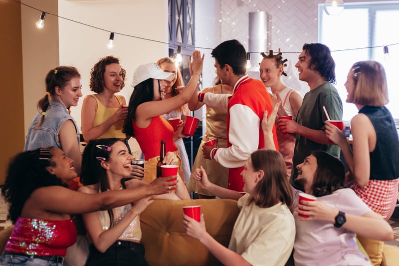Friends laughing and celebrating together at an indoor party.